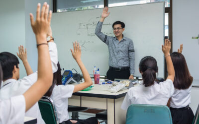 Asian teacher Giving Lesson over the the physics formular on white board in science laboratory classroom and students showing the hand for answer,school education concept,The teacher wrote himself