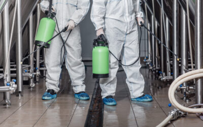 Cleaning of craft beer production. Guys in hazmat suits and masks disinfect equipment, cropped, free space